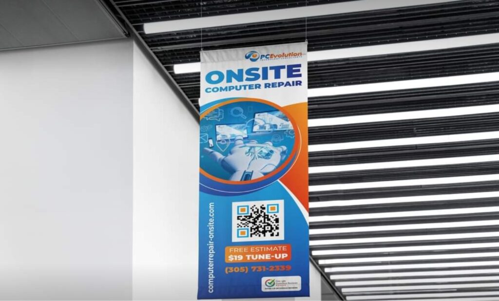 A vertical banner hanging indoors reads "Onsite Computer Repair" with the PC Evolution logo, seamlessly highlighting "computer repair" services. It features images of electronic devices, a QR code, and contact info: Free Estimate, $19 Tune-up, (305) 731-2339, computer-repair-onsite.com. computer repair